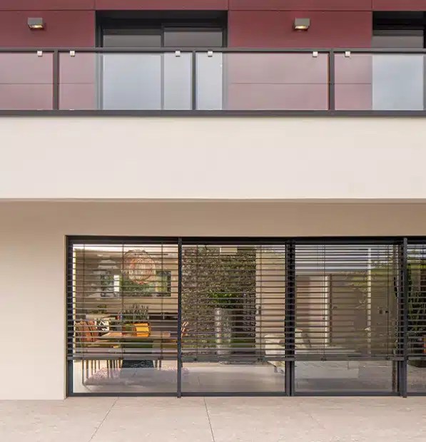 Brise-soleil orientable à lames ouvertes protégeant une grande baie vitrée