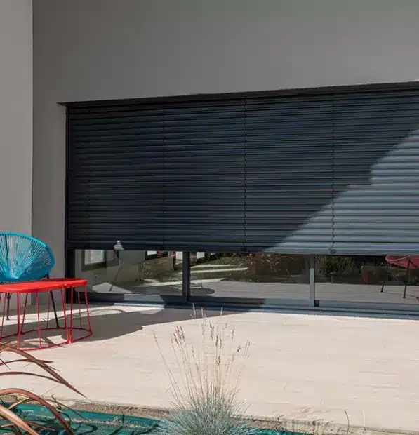 Brise-soleil orientable semi-ouvert filtrant la lumière sur terrasse